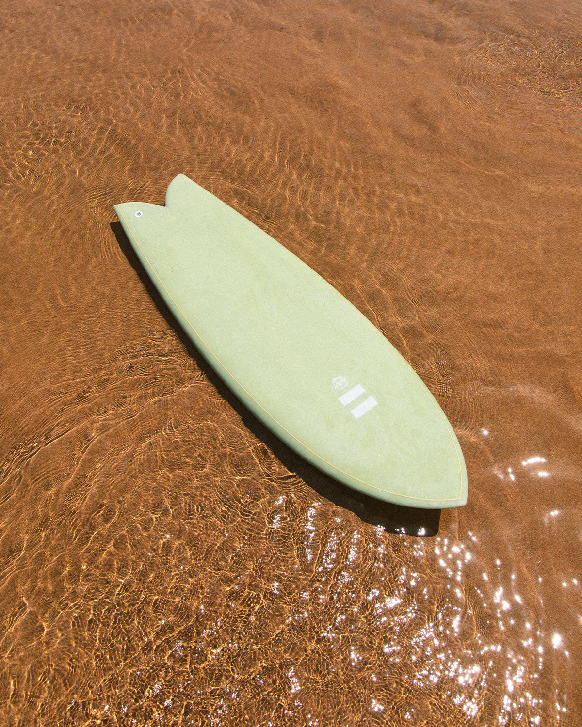 Indio DAB surfboard showing its shape in shallow water