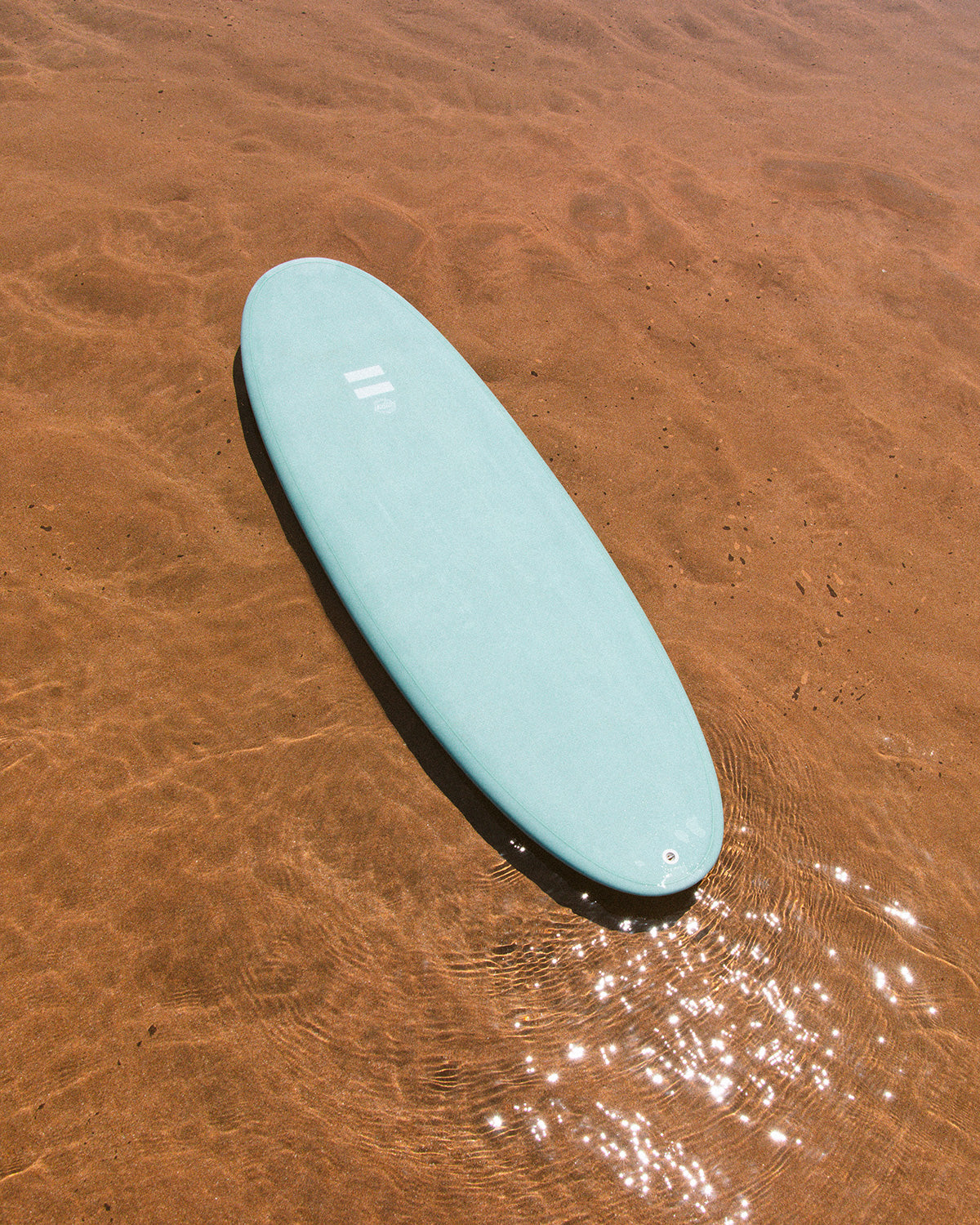 Indio Plus surfboard showing its shape in shallow water