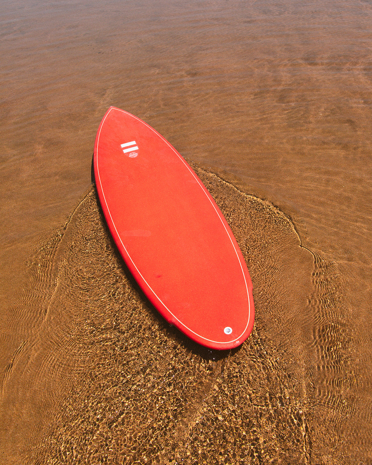 Indio Rancho surfboard showing its shape in shallow water